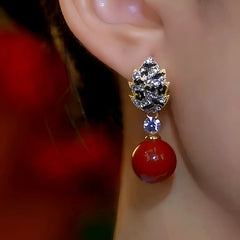Model showcasing the dangle and style of the 14K Gold-Plated Diamond Red Pearl Earrings