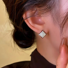 Model showcasing the dangle and style of the 14K Gold-Plated Diamond Square Stud Earrings