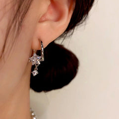 Model showcasing the dangle and style of the 14K Gold-Plated Diamond Star Earrings