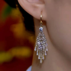 Model showcasing the dangle and style of the 14K Gold-Plated Diamond Tassel Earrings