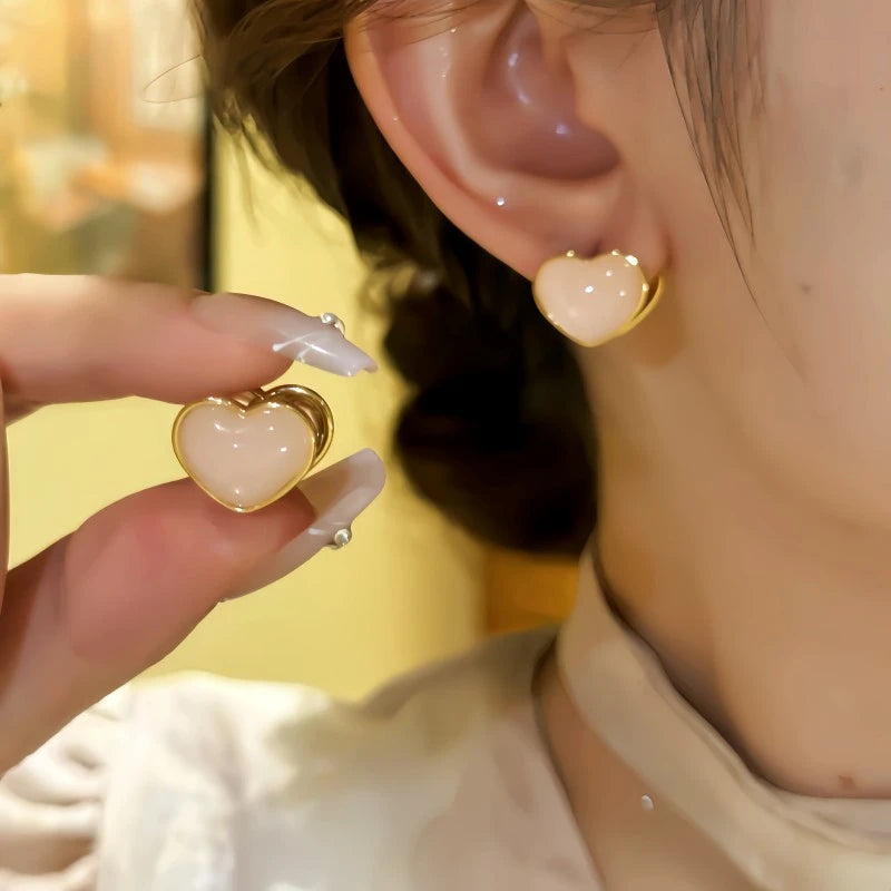 Model showcasing the dangle and style of the 14K Gold-Plated Double-Sided Heart Earrings