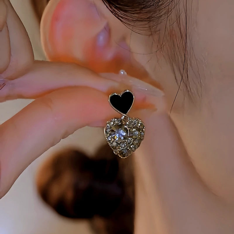 Angled view of the 14K Gold-Plated Elegan Black Heart Rhinestone Earrings
