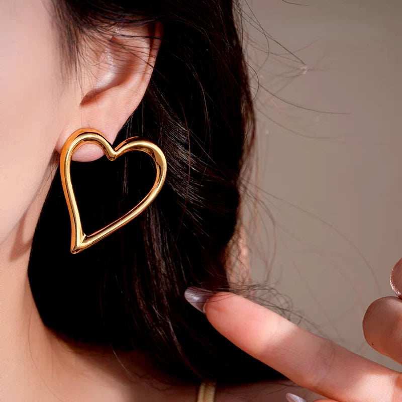 Model showcasing the dangle and style of the 14K Gold-Plated Elegant And Exquisite Hollow Heart Earrings