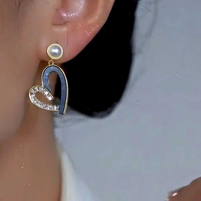 Model showcasing the dangle and style of the 14K Gold-Plated Elegant Asymmetrical Zircon Diamond Heart Pearl Tassel Earrings