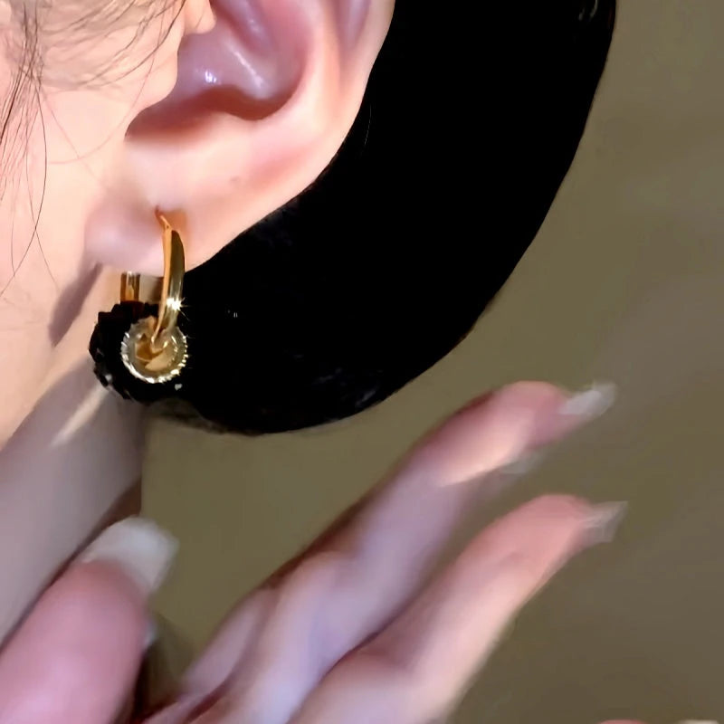 Model showcasing the dangle and style of the 14K Gold-Plated Elegant Black Crystal Ring Earrings