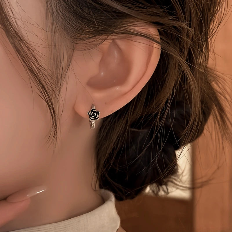 Model showcasing the dangle and style of the 14K Gold-Plated Elegant Black Rose Hoop Earrings