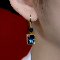 Model showcasing the dangle and style of the 14K Gold-Plated Elegant Blue Square Crystal Earrings