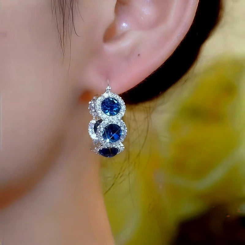Model showcasing the dangle and style of the 14K Gold-Plated Elegant Blue Zircon Diamond Hoop Earrings