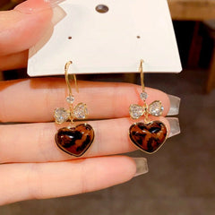 Angled view of the 14K Gold-Plated Elegant Bow Leopard Heart Ear Hooks