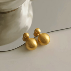 Model showcasing the dangle and style of the 14K Gold-Plated Elegant Brushed Ball Earrings