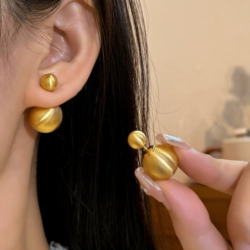 Angled view of the 14K Gold-Plated Elegant Brushed Ball Earrings