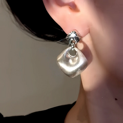 Model showcasing the dangle and style of the 14K Gold-Plated Elegant Brushed Water Drop Earrings