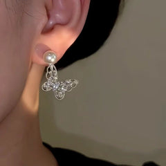 Model showcasing the dangle and style of the 14K Gold-Plated Elegant Butterfly Pearl Earrings