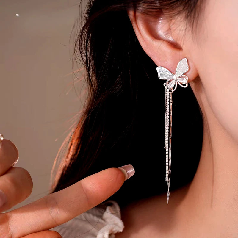 Model showcasing the dangle and style of the 14K Gold-Plated Elegant Butterfly Tassel Earrings