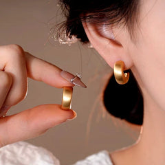 Model showcasing the dangle and style of the 14K Gold-Plated Elegant C-Shaped Earrings