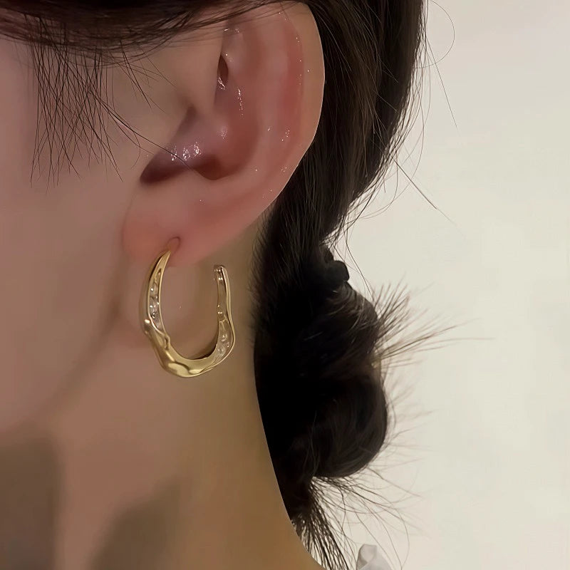 Model showcasing the dangle and style of the 14K Gold-Plated Elegant C-Shaped Pearl Earrings