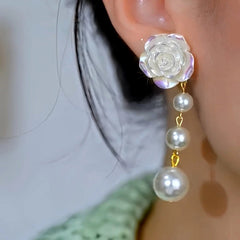 Model showcasing the dangle and style of the 14K Gold-Plated Elegant Camellia Bead Tassel Earrings