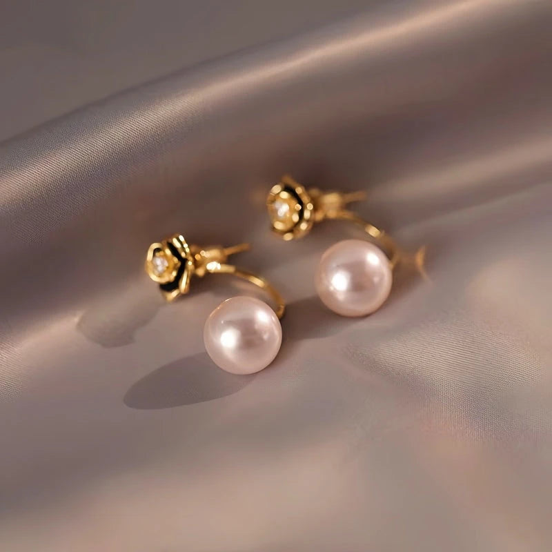Model showcasing the dangle and style of the 14K Gold-Plated Elegant Camellia Pearl Earrings