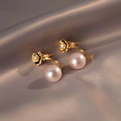 Model showcasing the dangle and style of the 14K Gold-Plated Elegant Camellia Pearl Earrings