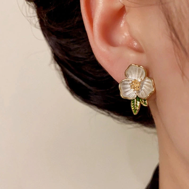 Model showcasing the dangle and style of the 14K Gold-Plated Elegant Camellia Stud Earrings