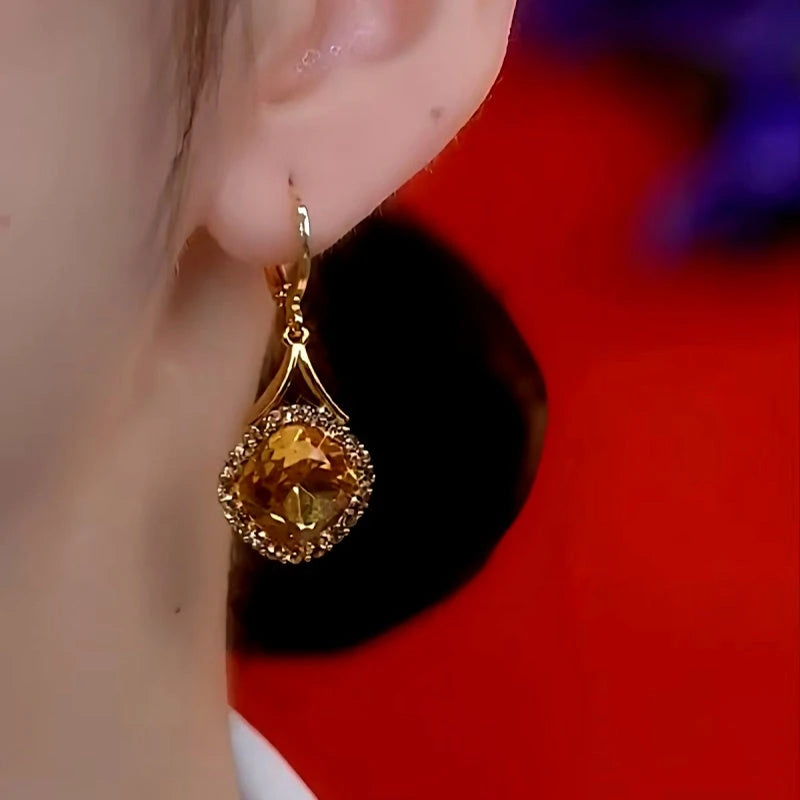Model showcasing the dangle and style of the 14K Gold-Plated Elegant Caramel Zircon Drop Earrings