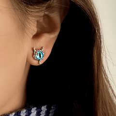 Model showcasing the dangle and style of the 14K Gold-Plated Elegant Cat's Eye Stone Devil Stud Earrings