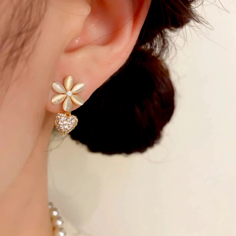 Model showcasing the dangle and style of the 14K Gold-Plated Elegant Cat's Eye Stone Diamond Heart Earrings