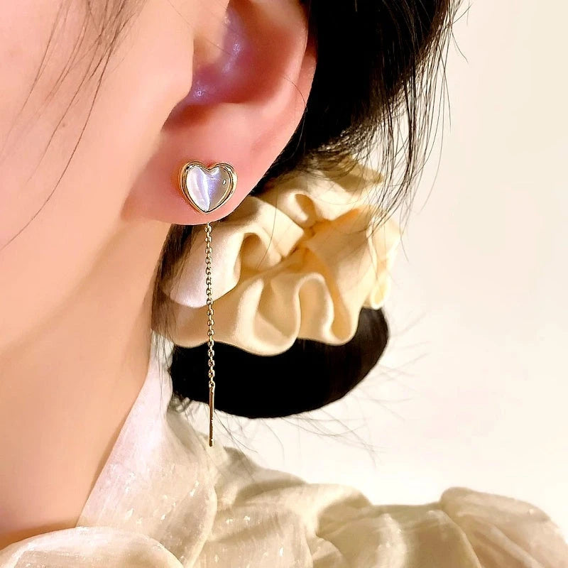 Model showcasing the dangle and style of the 14K Gold-Plated Elegant Cat's Eye Stone Heart Threader Earrings