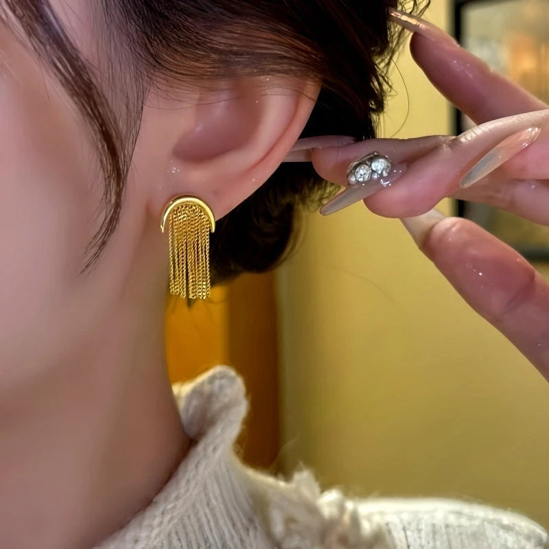 Model showcasing the dangle and style of the 14K Gold-Plated Elegant Chain Tassel Earrings