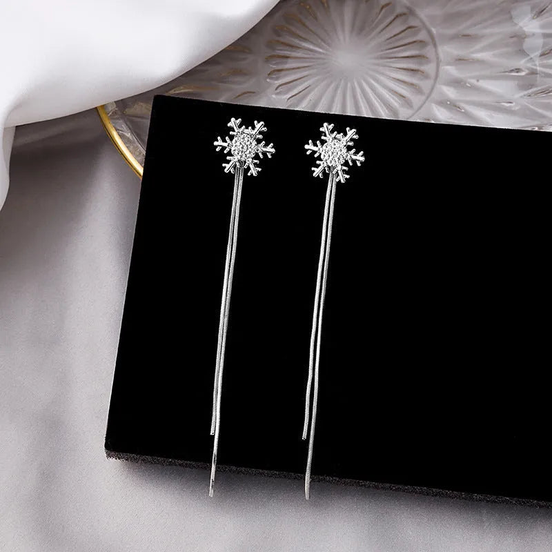 Model showcasing the dangle and style of the 14K Gold-Plated Elegant Christmas Snowflake Tassel Earrings