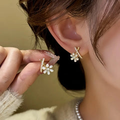 Model showcasing the dangle and style of the 14K Gold-Plated Elegant Cross Bead Flower Earrings