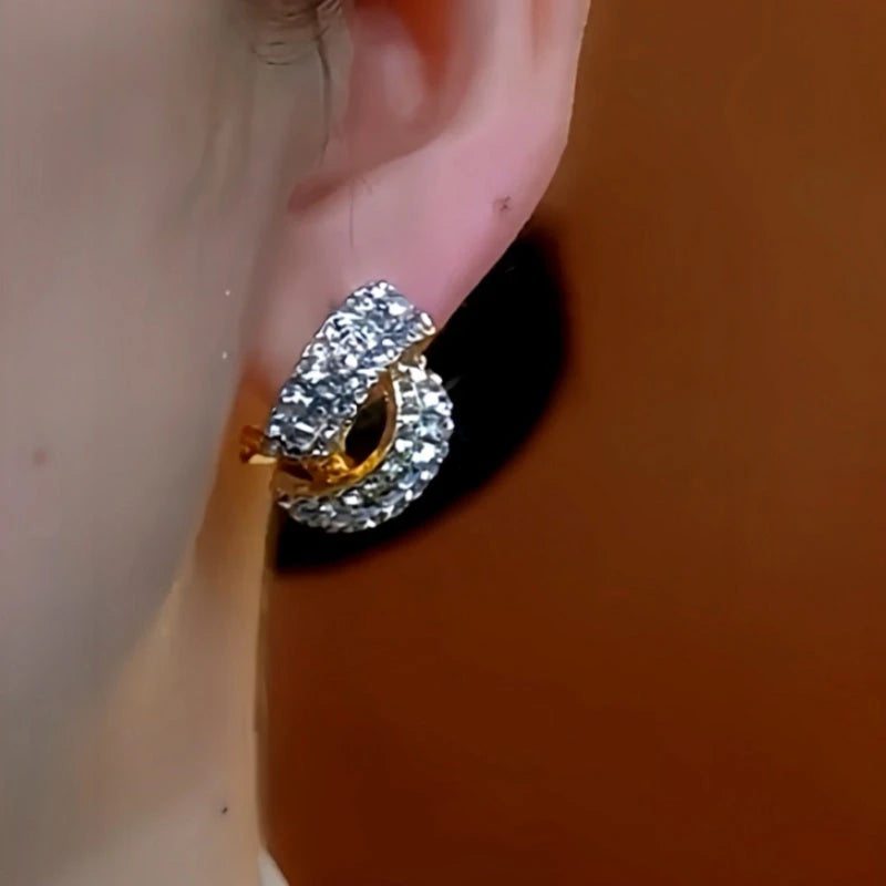 Model showcasing the dangle and style of the 14K Gold-Plated Elegant Cross Diamond Earrings