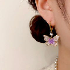 Model showcasing the dangle and style of the 14K Gold-Plated Elegant Crystal Butterfly Earrings