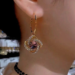 Model showcasing the dangle and style of the 14K Gold-Plated Elegant Crystal Flower Diamond Earrings