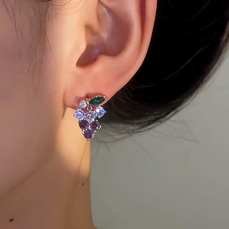 Model showcasing the dangle and style of the 14K Gold-Plated Elegant Crystal Grape Earrings