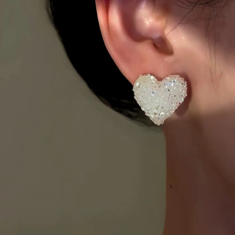 Model showcasing the dangle and style of the 14K Gold-Plated Elegant Crystal Heart Stud Earrings