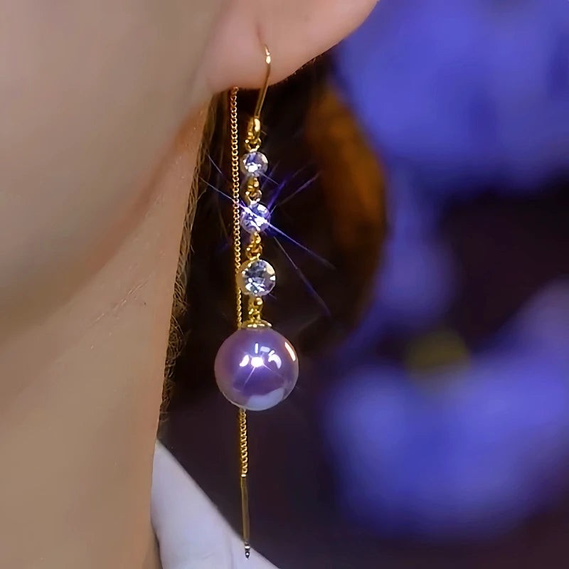 Model showcasing the dangle and style of the 14K Gold-Plated Elegant Diamond-Studded Purple Pearl Threader Earrings