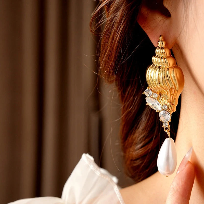 Model showcasing the dangle and style of the 14K Gold-Plated Elegant Diamond Conch Drop Pearl Earrings