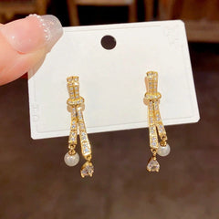 Close-up detail of the sparkling zircons and plating on the Knotted Drop Earrings