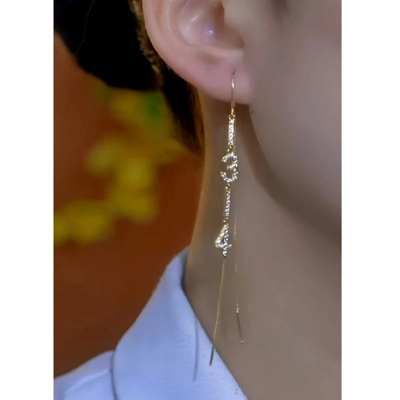 Model showcasing the dangle and style of the 14K Gold-Plated Elegant Diamond Number Threader Tassel Earrings