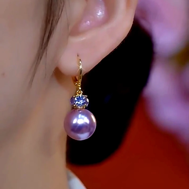 Model showcasing the dangle and style of the 14K Gold-Plated Elegant Diamond Purple People Earrings