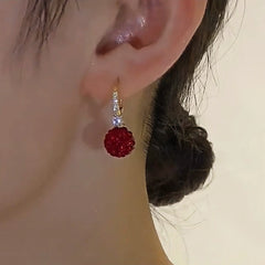 Close-up detail of the sparkling zircons and plating on the Red Ball Earrings