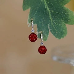 Angled view of the 14K Gold-Plated Elegant Diamond Red Ball Earrings