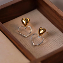 Model showcasing the dangle and style of the 14K Gold-Plated Elegant Double-Heart Earrings