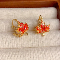 Model showcasing the dangle and style of the 14K Gold-Plated Elegant Double-Sided Maple Leaf Earrings