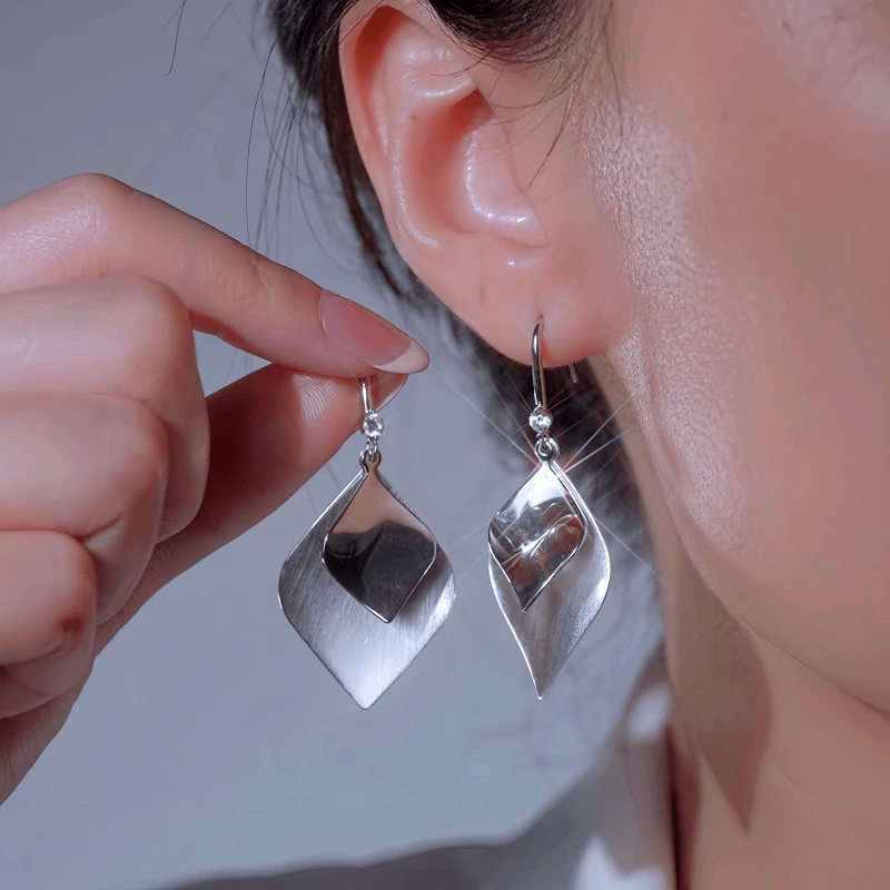 Model showcasing the dangle and style of the 14K Gold-Plated Elegant Double Leaf Ear Hook Earrings