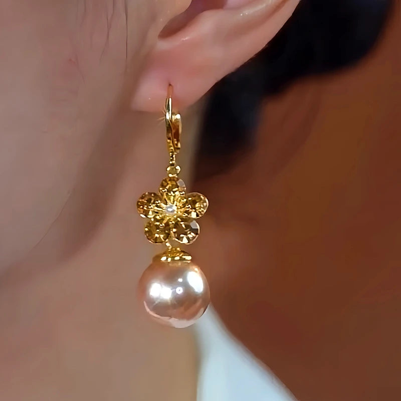 Model showcasing the dangle and style of the 14K Gold-Plated Elegant Flower Champagne Pearl Earrings