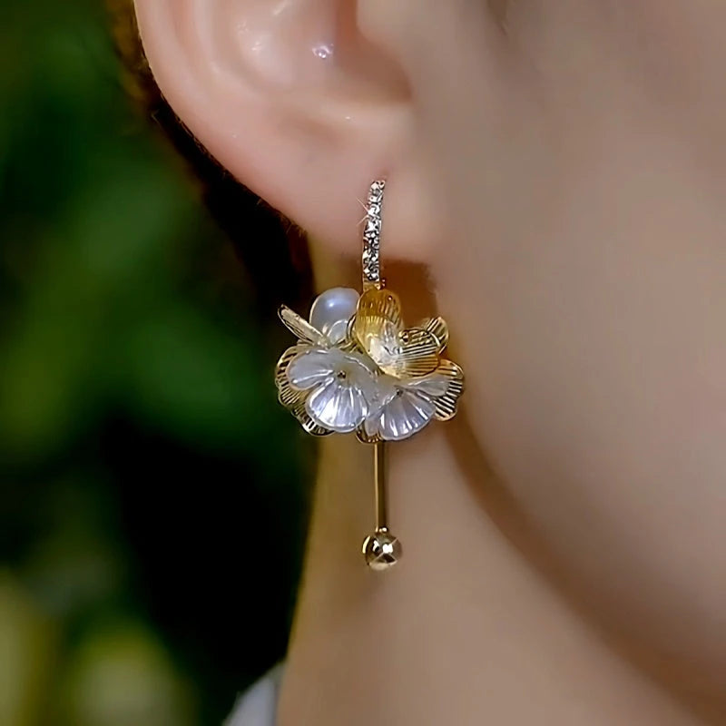 Model showcasing the dangle and style of the 14K Gold-Plated Elegant Flower Tassel Earrings