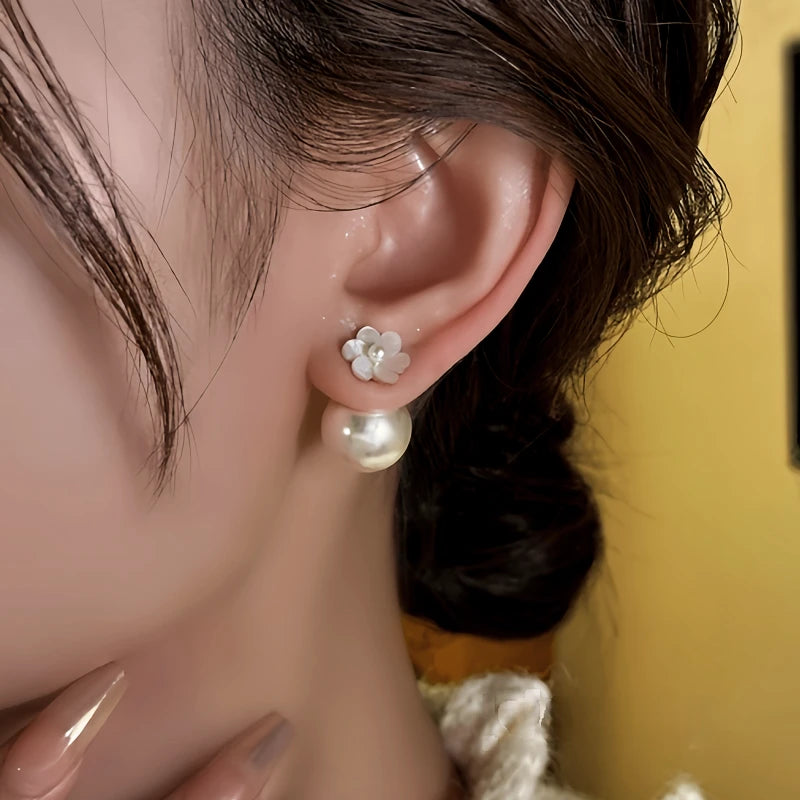 Model showcasing the dangle and style of the 14K Gold-Plated Elegant Font And Back Flower Pearl Jacket Earrings