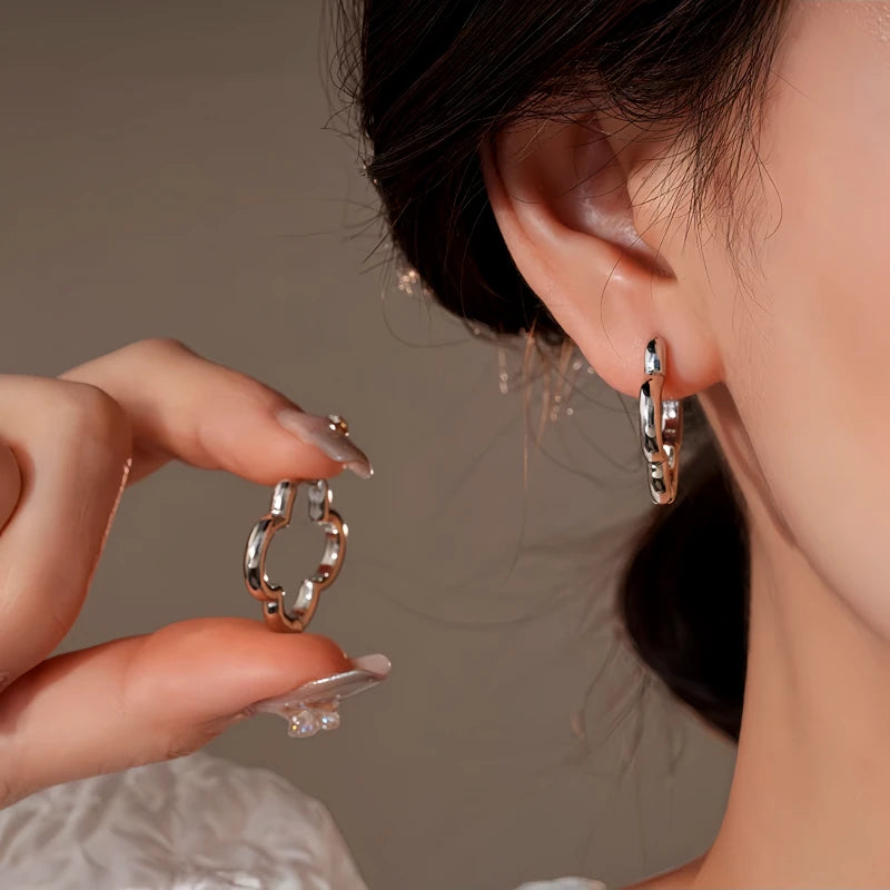 Model showcasing the dangle and style of the 14K Gold-Plated Elegant Four-Leaf Clover Earrings